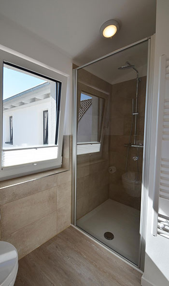 Badezimmer mit Regendusche, Handtuchheizkörper, Fön und Spiegel